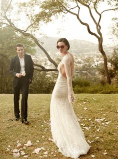 a man and woman standing in the grass