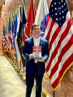 a man standing in front of flags holding a sign