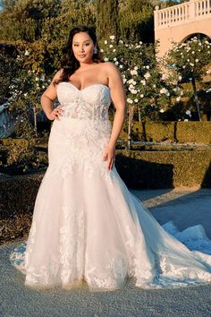 a woman in a white wedding dress posing for a photo with her hands on her hips