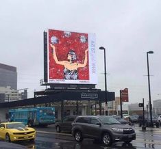 cars are parked in front of a building with a large billboard on it's side