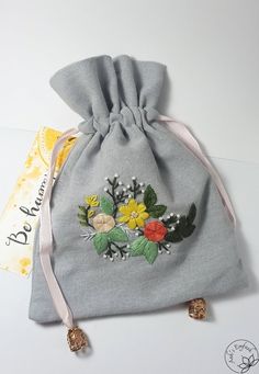 a gray bag with flowers and leaves on it