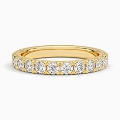 a yellow gold wedding band with five round diamonds on the bottom and two rows of white stones