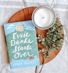 a book and candle on a wooden plate