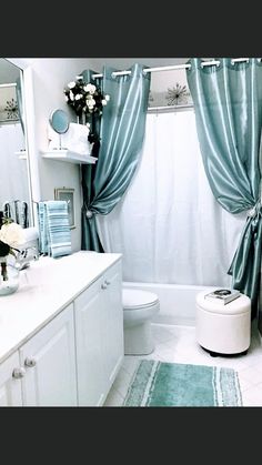 a bathroom with blue curtains and white fixtures