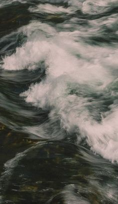 the water is very choppy and white as it moves through the rocks near the shore