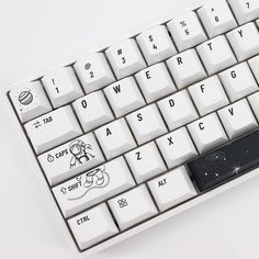 a white keyboard with black keys and astro stickers on the bottom part of it