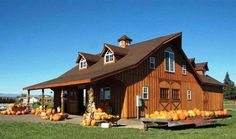 an old barn with pumpkins on the ground