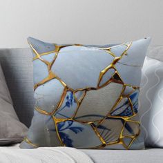 a blue and white pillow sitting on top of a couch