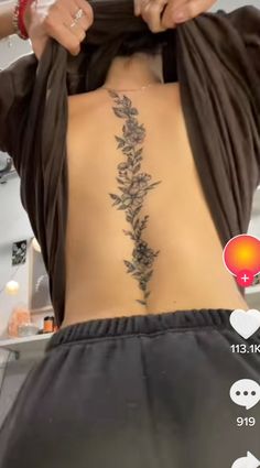 a woman is showing off her back tattoo