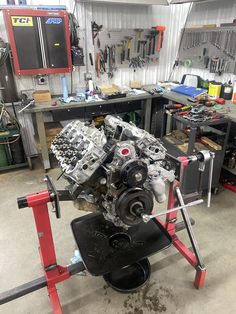 an engine is being worked on in a garage with tools and other workbenches