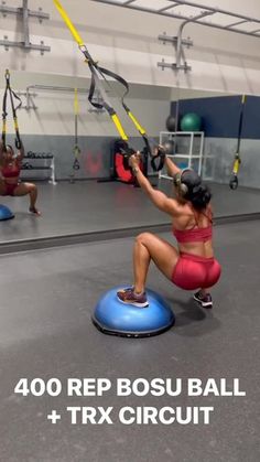 a woman is doing exercises on a blue exercise ball in a crossfit gym