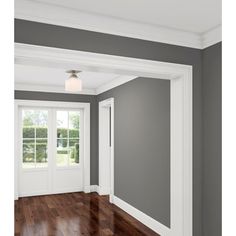 an empty room with hard wood floors and gray walls