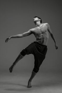 a shirtless man is doing a dance move with his leg up in the air