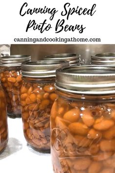 several jars filled with beans sitting on top of a white counter next to each other