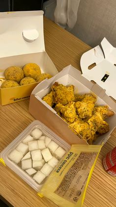 two boxes filled with food sitting on top of a wooden table next to each other