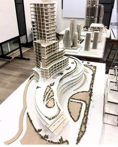 an architectural model of a city with skyscrapers and buildings in the foreground, on display