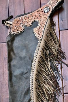 a brown and black purse with fringes on the inside is sitting on a wooden floor