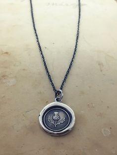 "This Scottish Thistle Wax Seal Necklace makes the perfect gift for a friend or a reminder of your Scottish heritage. Read on to learn about its symbolism and history. Scottish Thistle Wax Seal Necklace, even more beautiful in person, this silver thistle charm is the national flower of Scotland, the meaning \"No One Provokes Me With Impunity\". One thistle is said to have saved an entire Scottish army. This vintage wax seal more then likely sat forgotten in the back of desk drawer until we acqui Bookmark Keychain, Scottish Jewelry, Thistle Necklace, Xo Necklace, Wax Seal Pendant, Seal Necklace, Wax Seal Jewelry, Wax Seal Necklace, Feminine Necklace