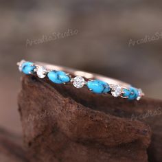 a close up view of a turquoise and white stone ring on top of a piece of wood