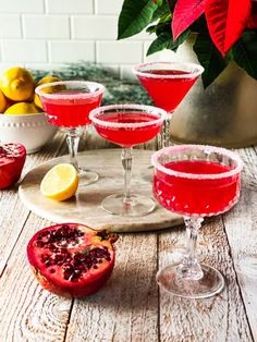 three wine glasses filled with pomegranate and garnished with lemons