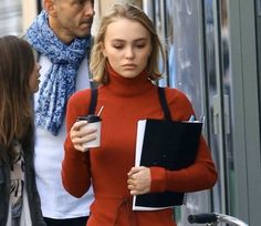 a woman in a red sweater is holding a coffee