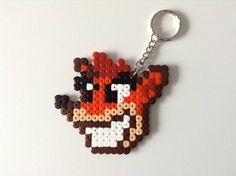 a keychain made to look like a pixelated animal with an orange and black face