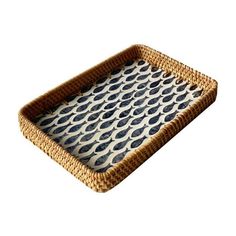 a woven tray with blue and white designs on it's sides, sitting in front of a white background