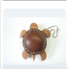 a small stuffed turtle with a leather shell on it's back, sitting on a white surface