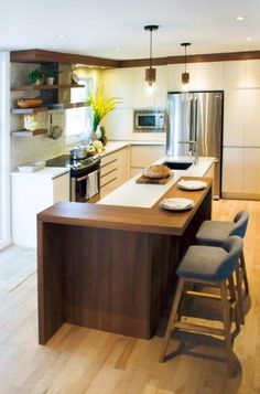 a modern kitchen with an island counter and stools