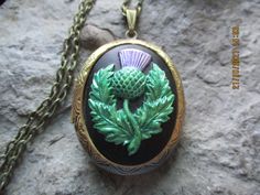 "Beautiful silver plated locket. Scotland's national emblem since the 1400's. The thistle has amazing details and is hand painted, antiqued, and sealed by me, so each is an original. This particular ones is done in metallic paint, I do have other styles, so please do browse my shop. Please feel free to message me for custom colors. The locket is Victorian style with beautiful etching on both the front and back 2\" long. It can hold two photos, or a treasured keepsake. Pass down from generation t Bronze Historical Design Jewelry As A Gift, Antique Coat Of Arms Jewelry For Formal Occasions, Vintage Formal Coat Of Arms Jewelry, Historical Gold Jewelry For Weddings, Traditional Oval Jewelry With Antique Finish, Vintage Silver Jewelry With Coat Of Arms, Ceremonial Medallion Jewelry With Historical Design, Historical Medallion Jewelry For Gift, Green Locket Wedding Jewelry