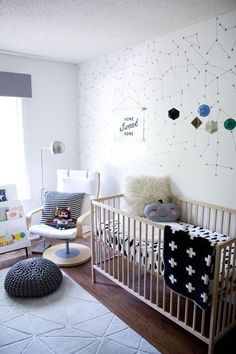 a baby's room is decorated in white and black with stars on the wall