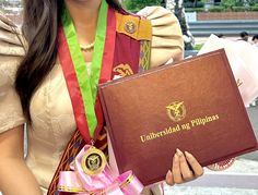 a woman is holding a book with ribbons around her neck