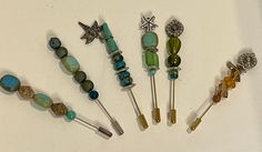 six different types of hair pins and brooches on a white surface with beads