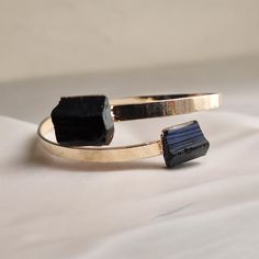 High quality black tourmaline set on an adjustable gold plated bangle . These stones are polished but please expect some minor dents and divots, these are not flaws but part of the beauty of these natural stones. Listing is for one bracelet only. ✦ DETAILS ✦ ✧ Genuine Natural Black Tourmaline Crystals ✧ Stones measure approx. 12 x 10mm but each stone is different  ✧ Gold plated 4mm bangle cuff. ✧Also available in selenite ✧Usually ships same day or next day and comes ready for gifting in a cute boho gift box. To see all the goodies in my shop, click here: www.etsy.com/shop/OneTribeJewelry ✦ GOLD CARE ✦ ✧ Warm water and a soft cloth are the best thing you can do to maintain the beauty of your jewelry. ✧ Jewelry polishing cloths work great and are non-abrasive. ✧ Salt water and chlorine in s Black Tourmaline Bracelet, Bracelet For Her, Black Tourmaline Crystal, Crystals Stones, Tourmaline Bracelet, Gold Plated Bangles, Tourmaline Jewelry, Bracelet Gemstone, Tourmaline Crystal