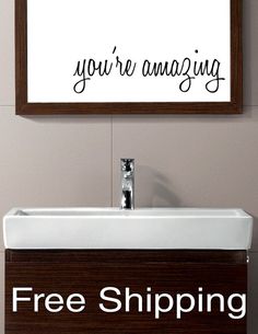 a bathroom sink with a framed sign above it