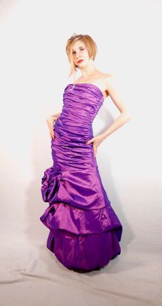 a woman in a purple dress posing for the camera