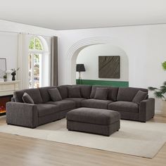 a large sectional couch sitting on top of a rug in a living room next to a fire place