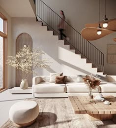 a living room filled with furniture and a stair case in front of a large window