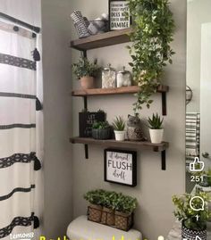 the bathroom is decorated in black and white with lots of greenery on the shelves