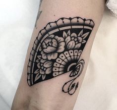 a woman's arm with a black and white tattoo design on the left forearm