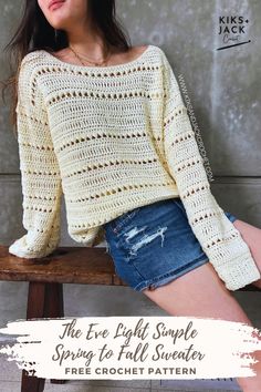 a woman sitting on top of a wooden bench wearing a white sweater and denim shorts