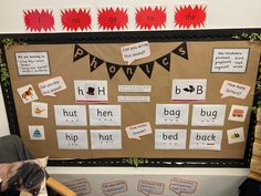 a bulletin board with words and pictures on it, along with a stuffed animal sitting in a chair