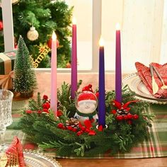 a christmas table setting with candles and decorations