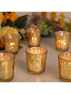 there are many small glass candles on the table