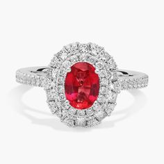 an oval shaped ruby and diamond ring with halos around the band, set in 18k white gold