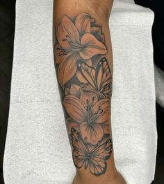 a woman's arm with flowers and butterflies on it