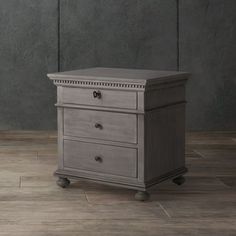 a small wooden dresser sitting on top of a hard wood floor next to a wall