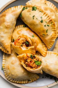 three empanas on a plate with some garnishes in the middle