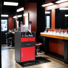 a hair salon with red and black furniture, mirrors and lights on the wall next to two sinks