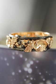 a close up of a gold ring with leaves on it